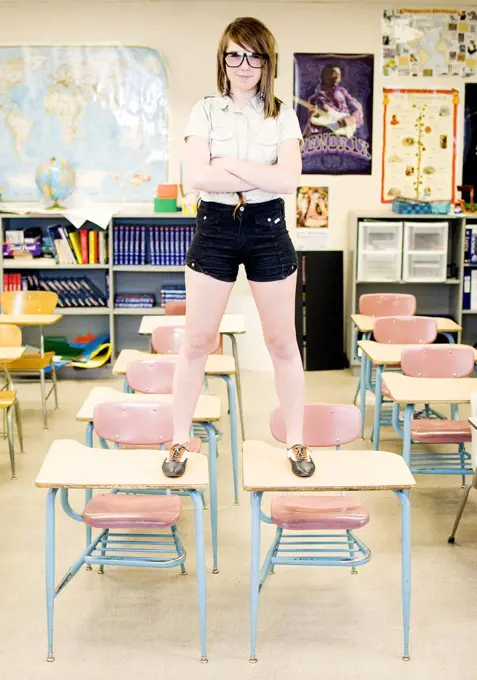 Confident High School Girl standing on desks