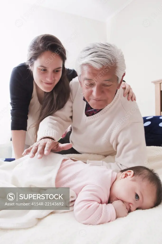 Grandfather and Mother with Baby At Home 