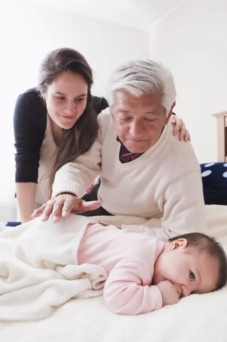 Grandfather and Mother with Baby At Home 