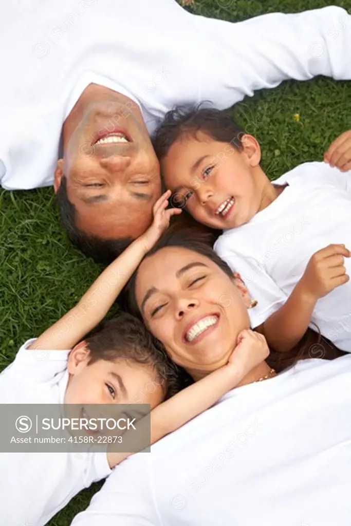 happy family smiling in a portrait of a mum and dad with their two kids