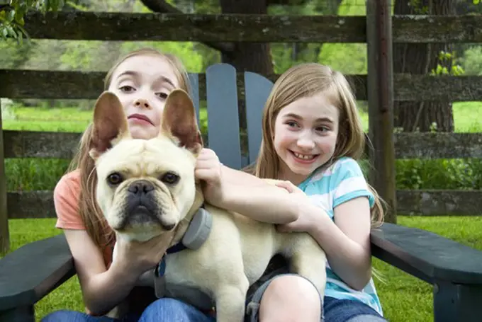 Two girls playing with a dog