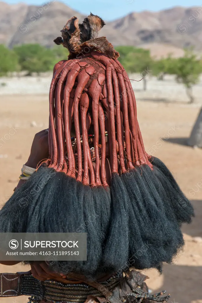 The Himba women have a unique hairstyle hat are complicated and require hours of preparation which involves braiding her hair and covering it in an unusual mixture of butter and ochre, such as here in a Himba settlement in the Damaraland of northwestern Namibia.