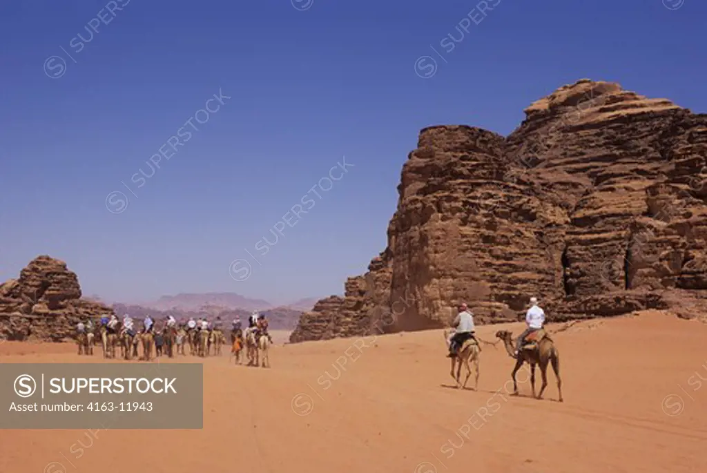 JORDAN, WADI RUM, TOURIST ON CAMEL RIDE