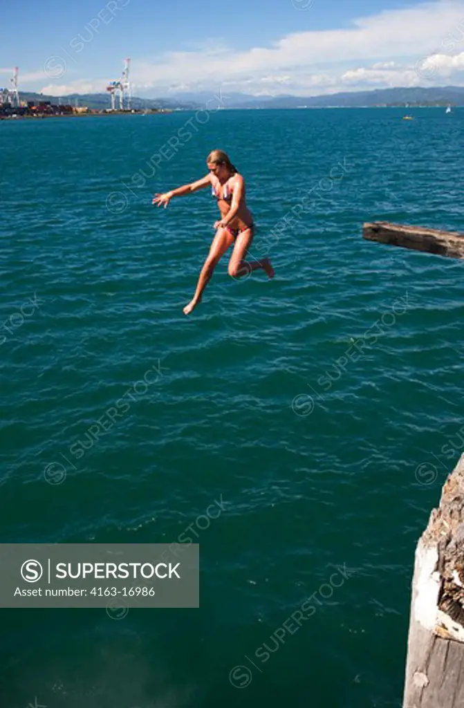 NEW ZEALAND, NORTH ISLAND, WELLINGTON, LAMBTON HARBOUR, GIRL JUMPING INTO WATER