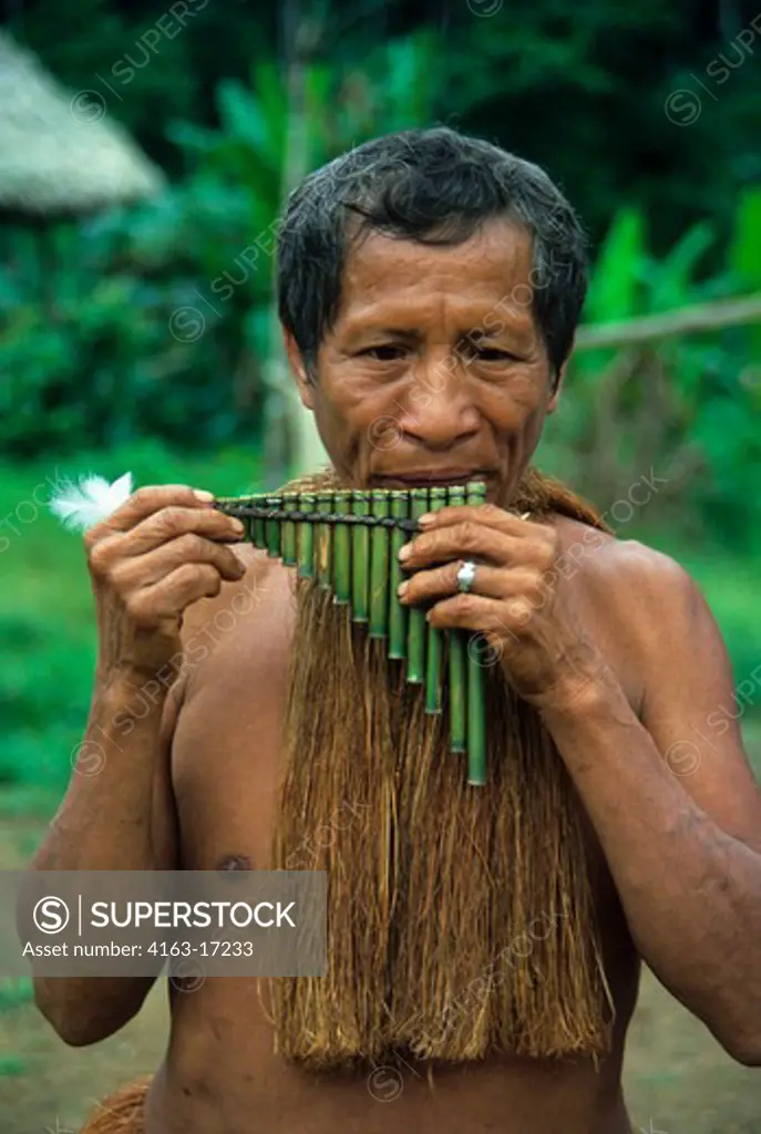 AMAZON RIVER, YAGUA INDIAN PLAYING TRADITIONAL REED FLUTE