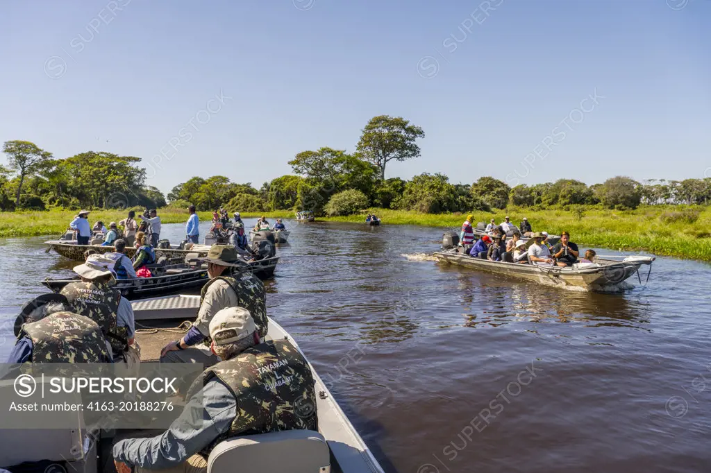 Tourists in boat on excursion to watch the wildlife in one of the tributaries of the Cuiaba River near Porto Jofre in the northern Pantanal, Mato Grosso province in Brazil.