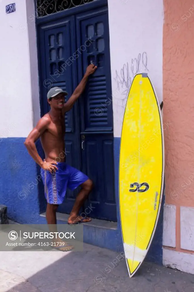 BRAZIL, NEAR RECIFE, OLINDA, STREET SCENE, MAN WITH SURFBOARD