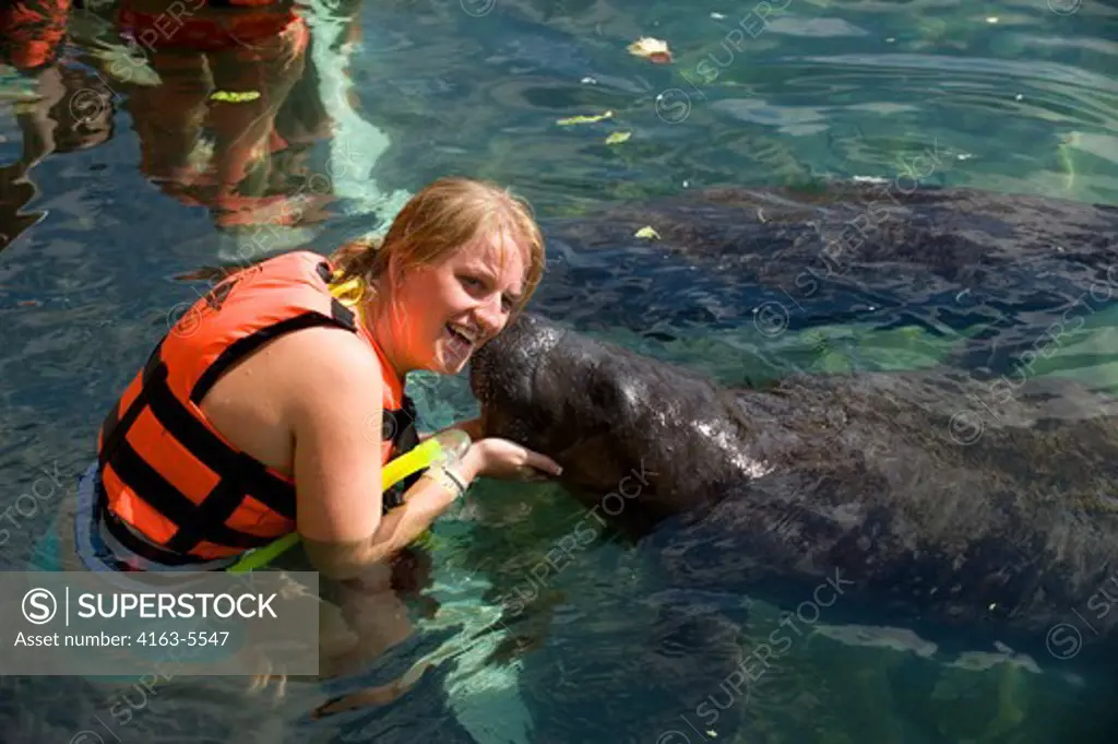 MEXICO, NEAR CANCUN, PUERTO AVENTURA, TOURIST WITH MANATEE