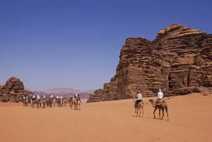 JORDAN, WADI RUM, TOURIST ON CAMEL RIDE