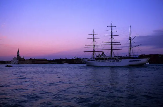 ITALY, VENICE, CANAL DELLA GIUDECCA, CRUISE SHIP SEA CLOUD II AT SUNSET.