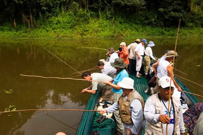 PERU, AMAZON BASIN, UCAYALI RIVER, PACAYA-SAMIRIA NATIONAL RESERVE, SMALL RIVER, RAINFOREST, TOURISTS IN BOAT FISHING FOR PIRANHA