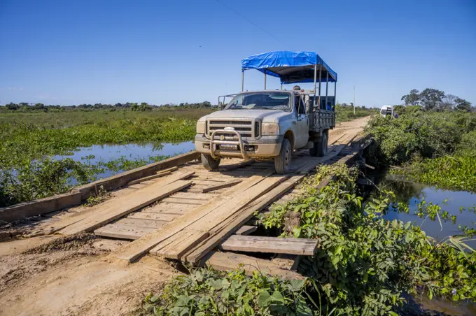 A safari vehicle is crossing one of the old wooden bridges of the Transpantaneira Highway in the northern Pantanal, Mato Grosso province of Brazil.