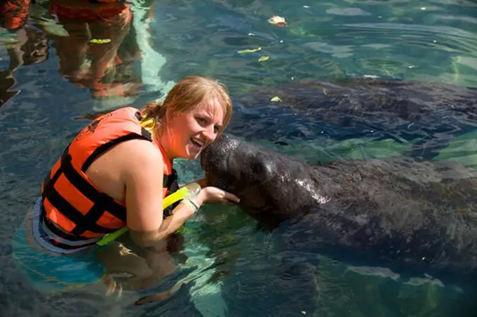 MEXICO, NEAR CANCUN, PUERTO AVENTURA, TOURIST WITH MANATEE