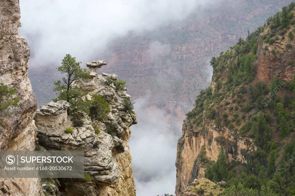 View of the Grand Canyon rock formations with clouds from Mather Point on the South Rim during a thunderstorm near the Grand Canyon Visitor Center in the Grand Canyon National Park in northern Arizona, USA.