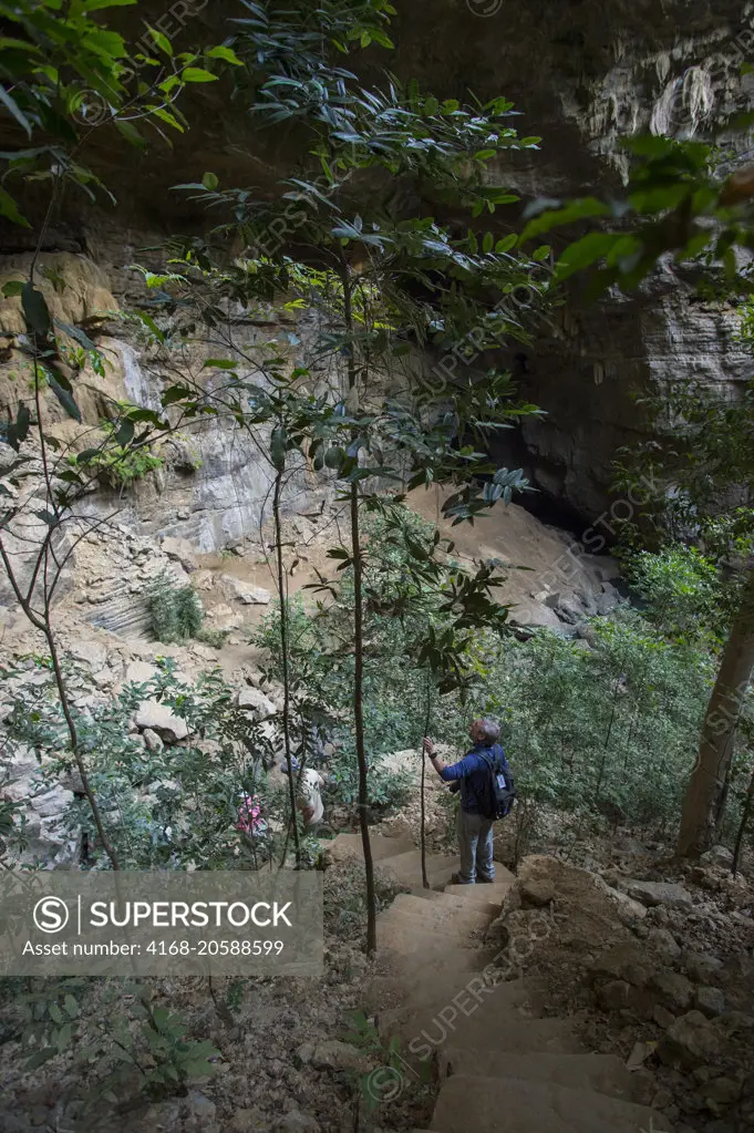 Tourists descending to limestone cave in Ankarana Reserve in Northern Madagascar.