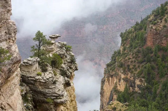 View of the Grand Canyon rock formations with clouds from Mather Point on the South Rim during a thunderstorm near the Grand Canyon Visitor Center in the Grand Canyon National Park in northern Arizona, USA.