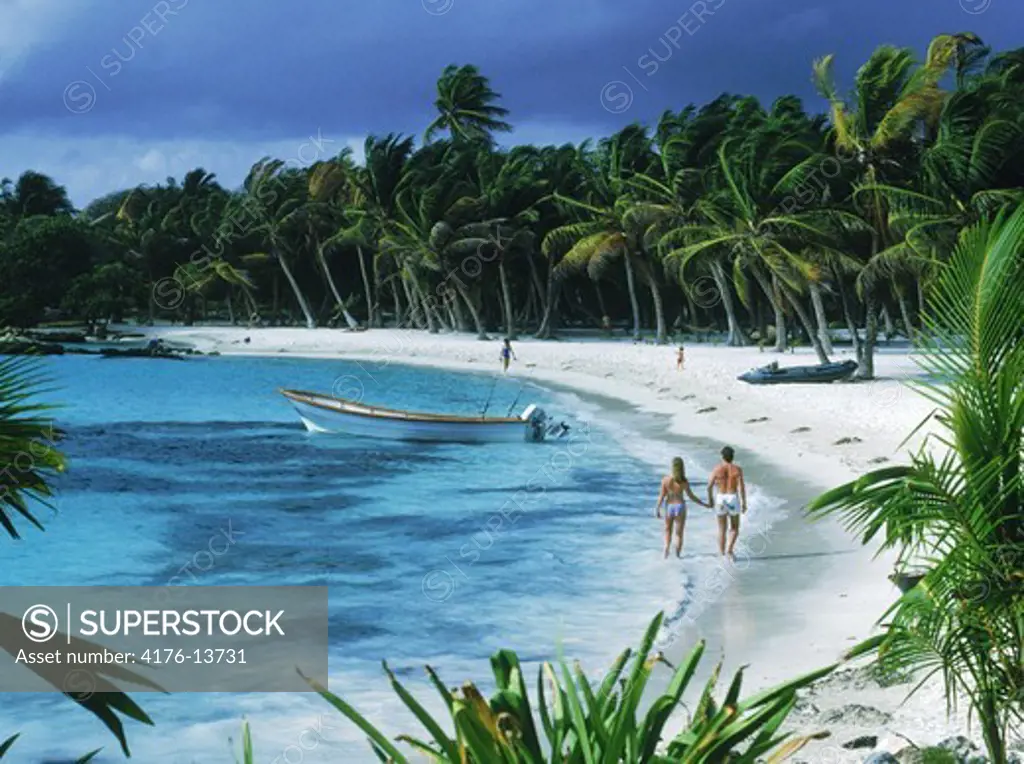 Caribbean sea and couple on coral sand beach along the Yucatan Peninsula in Mexico