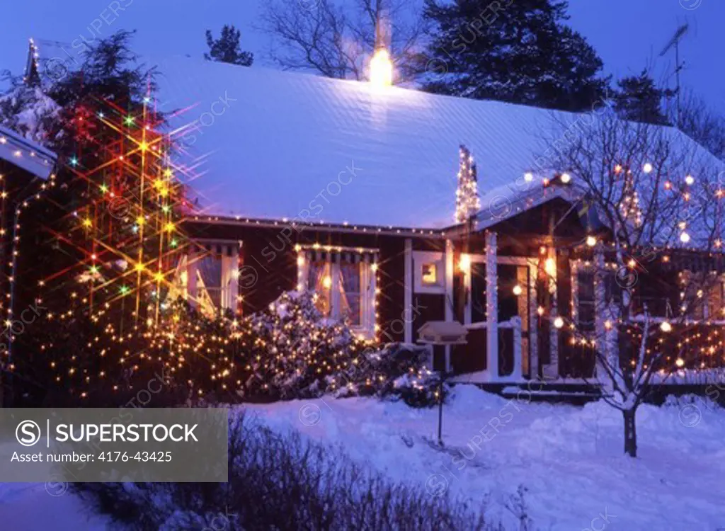 A decorated house with Christmas lights in the trees outside,Kvicksund,Sodermanland.