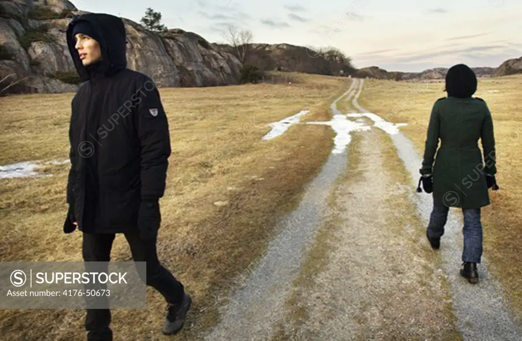 Two persons walking in different directions