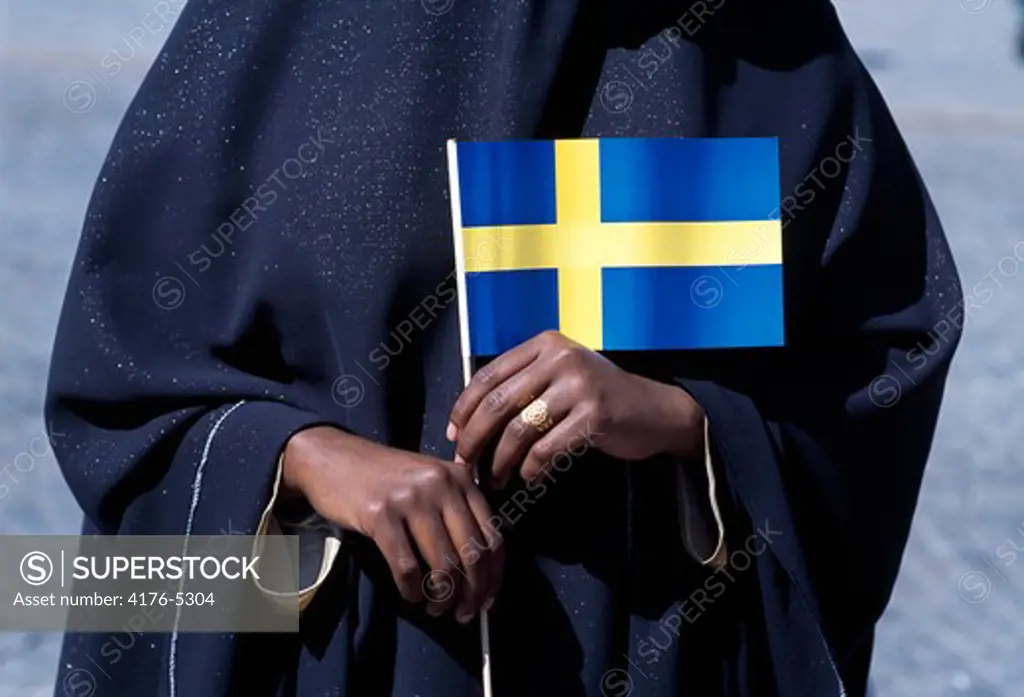 Close-up of a person holding a Swedish flag