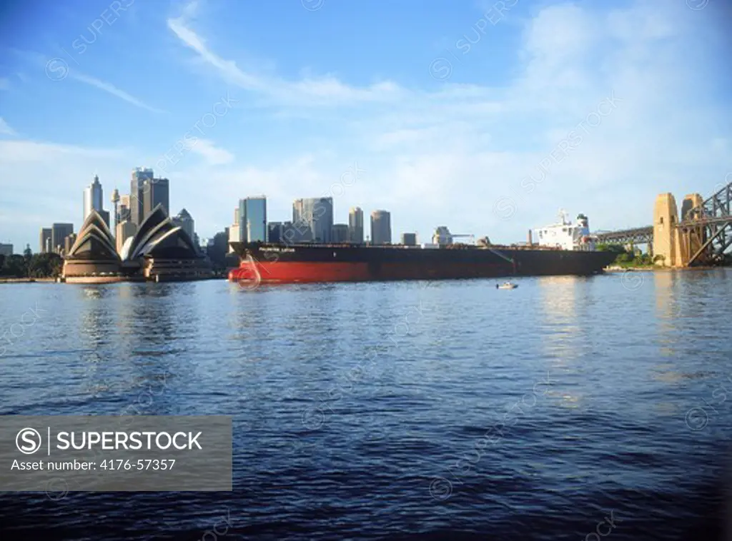 Oil tanker and cargo ship crossing Sydney Harbour with Opera House at sunrise