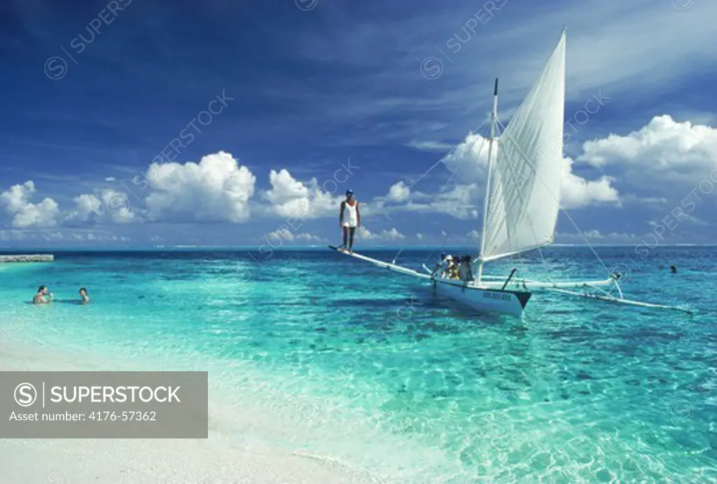 Outrigger canoe sailing with tourists off Island of Bora Bora in French Polynesia