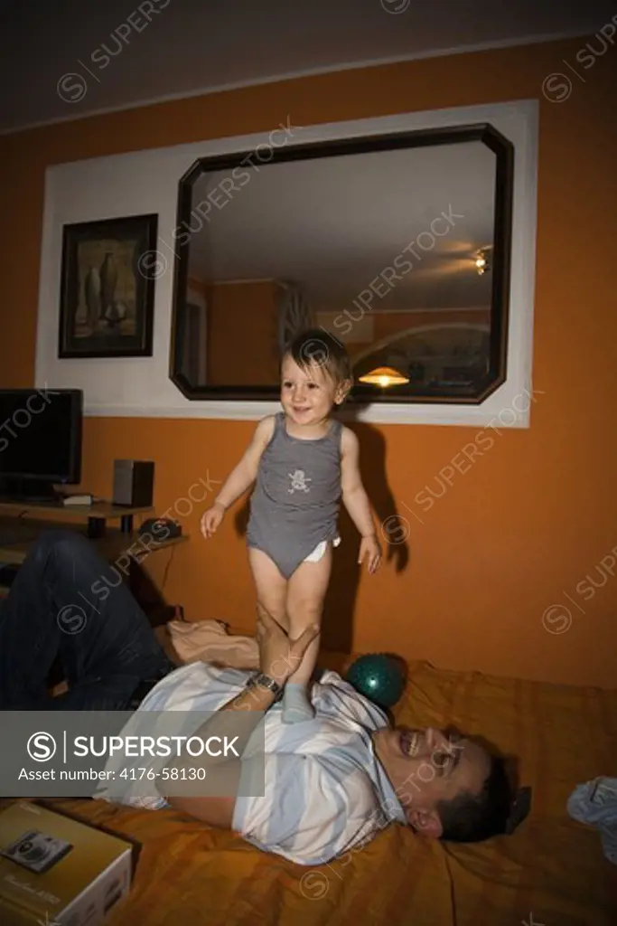 Smiling father and son on bed. Belgrade. Serbia