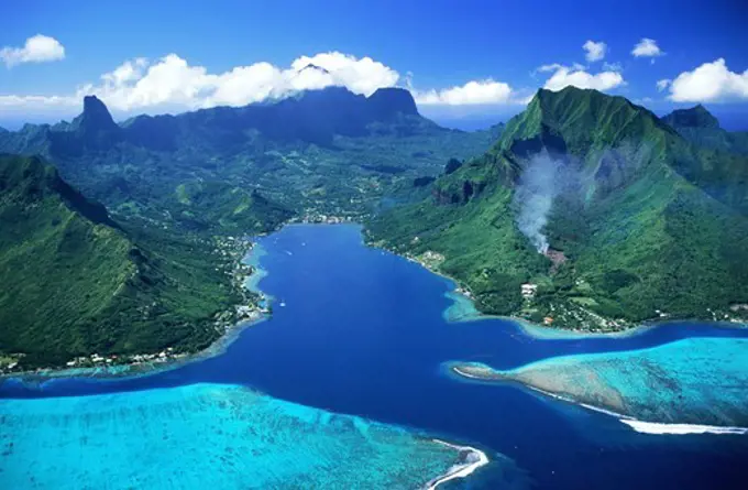 Aerial view of Cooks Bay and mountains on Island of Moorea swimming between blue skies and blue lagoons