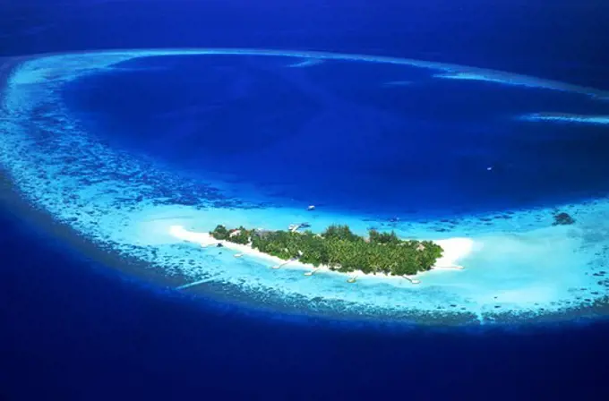 Aerial view of Mayafushi Island with encircling reef in Maldive Islands anchored in Indian Ocean in North East Ari Atoll