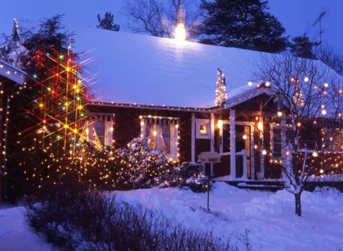 A decorated house with Christmas lights in the trees outside,Kvicksund,Sodermanland.