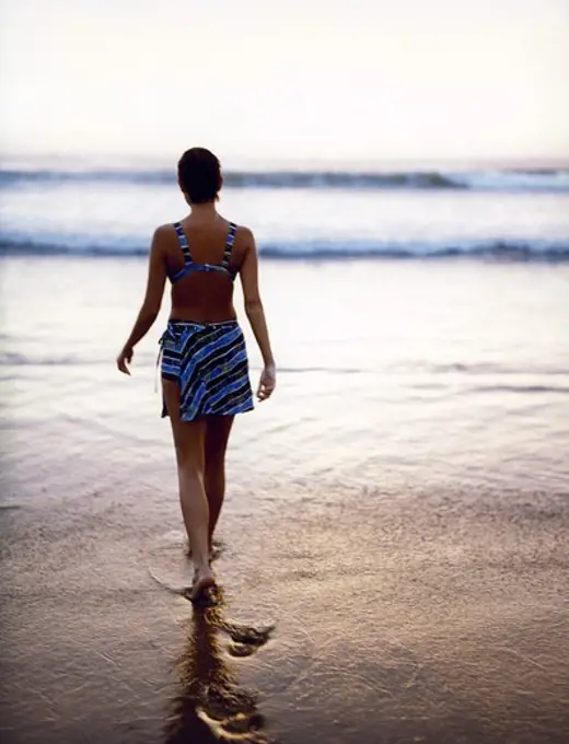 A woman walking into the water