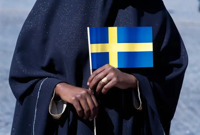 Close-up of a person holding a Swedish flag