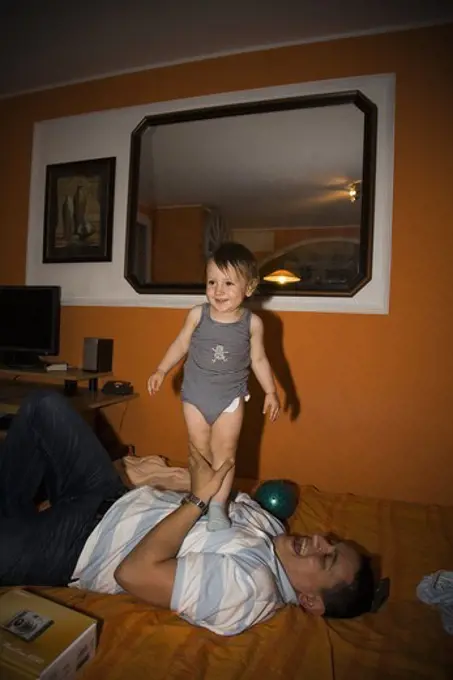 Smiling father and son on bed. Belgrade. Serbia