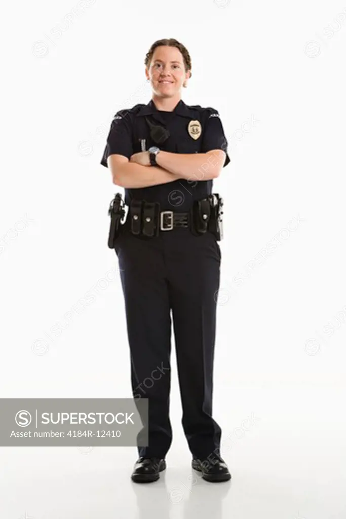 Portrait of mid adult Caucasian female law enforcement officer standing with arms crossed looking at viewer smiling.