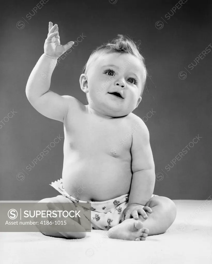 1950S Portrait Of Baby Sitting One Arm Raised Indoor