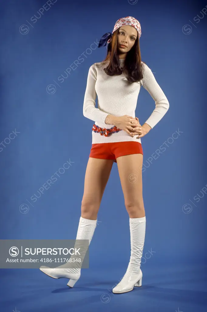 1970s STUDIO PORTRAIT WOMAN TEENAGE GIRL IN RED SHORT SHORTS AND DANCER FASHION WHITE GO-GO BOOTS