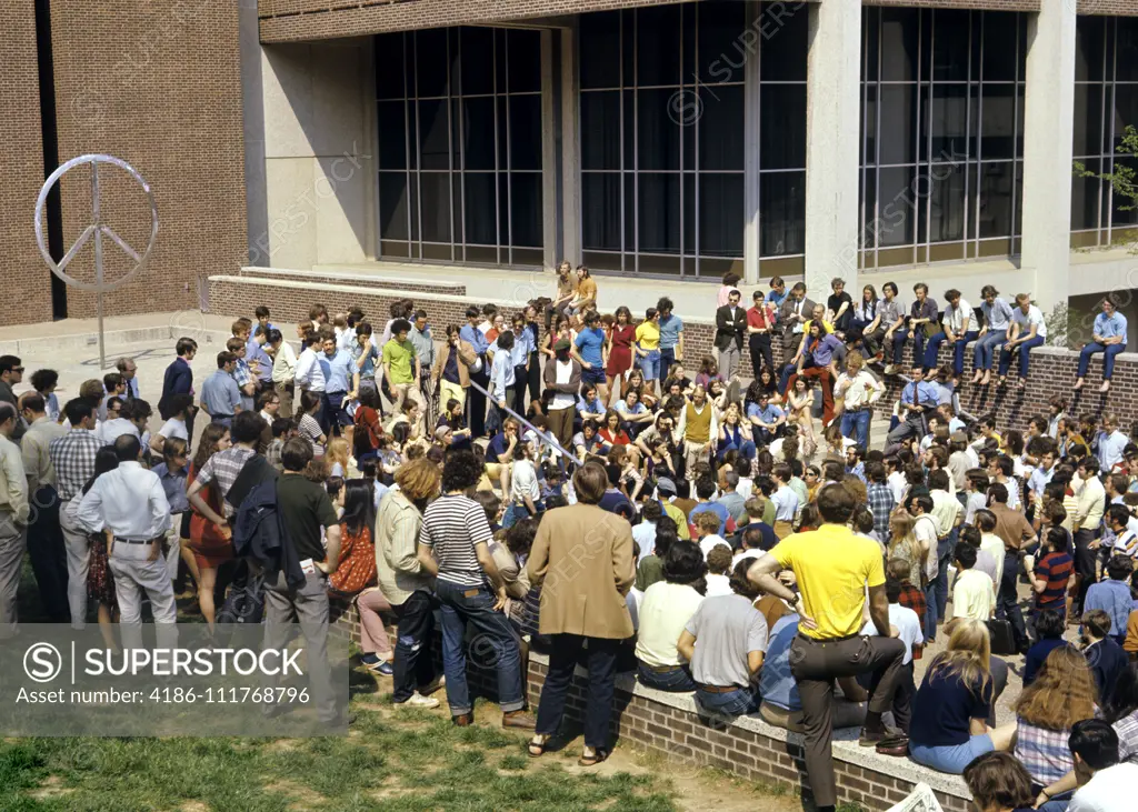 1960s 1970s GROUP OF ANTI-WAR STUDENT PROTESTERS GATHERING DEMONSTRATING NEAR PEACE SIGN