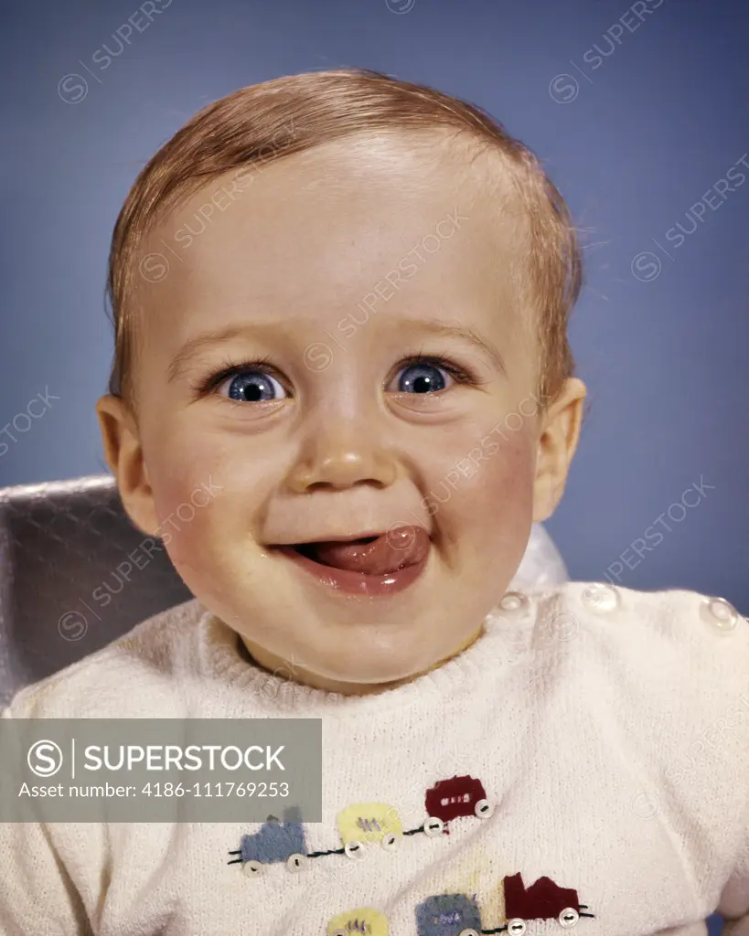 1960s HAPPY BABY BOY MAKING A FUNNY FACE LICKING HIS LIPS WITH HIS TONGUE