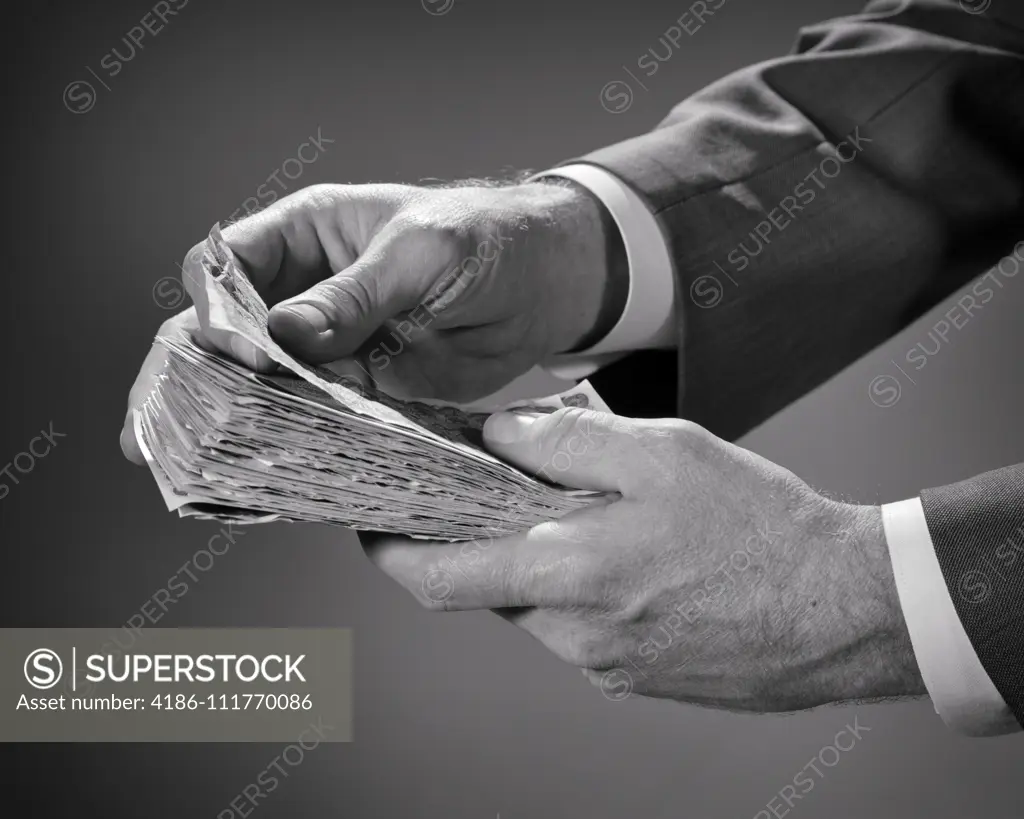 1960s MALE HAND HOLDING WAD OF CASH MONEY OTHER HAND PEALING OFF A SINGLE BILL