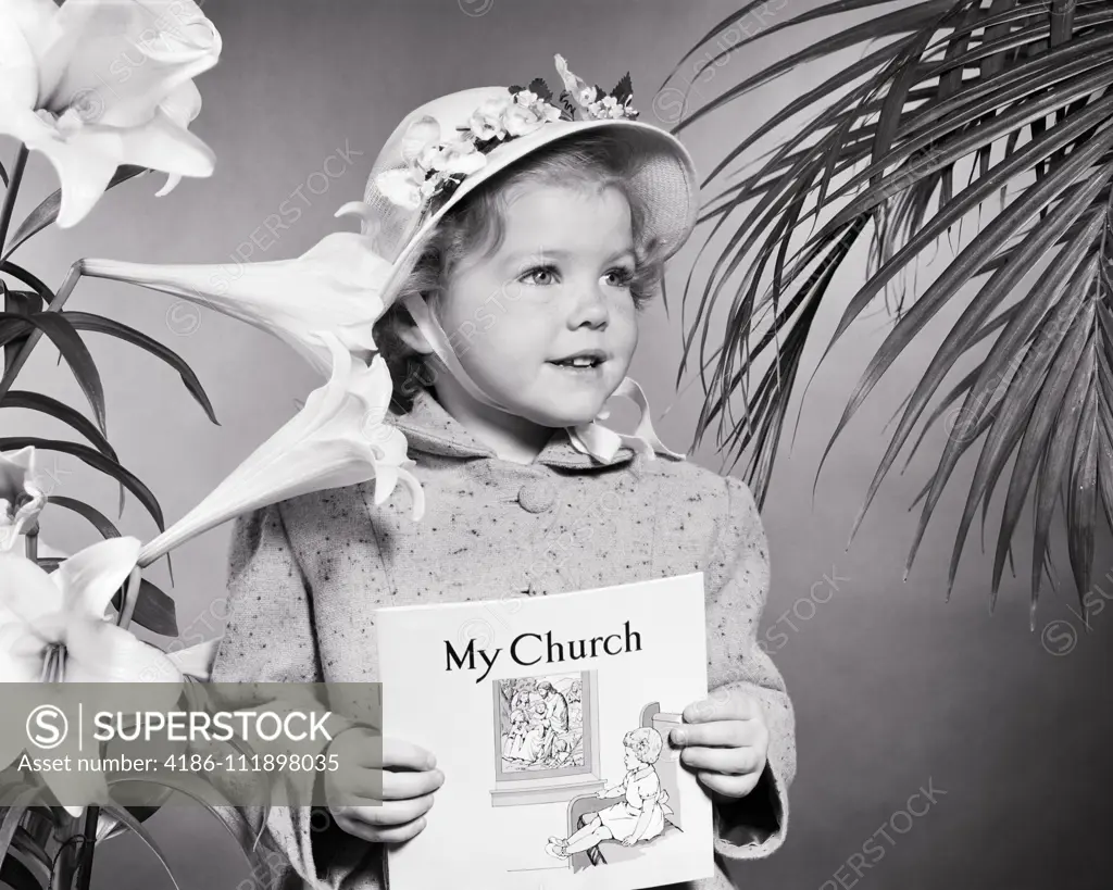 1950s LITTLE GIRL WEARING EASTER BONNET HOLDING MY CHURCH ACTIVITY BOOKLET EASTER LILIES TO RIGHT AND PALMS TO RIGHT