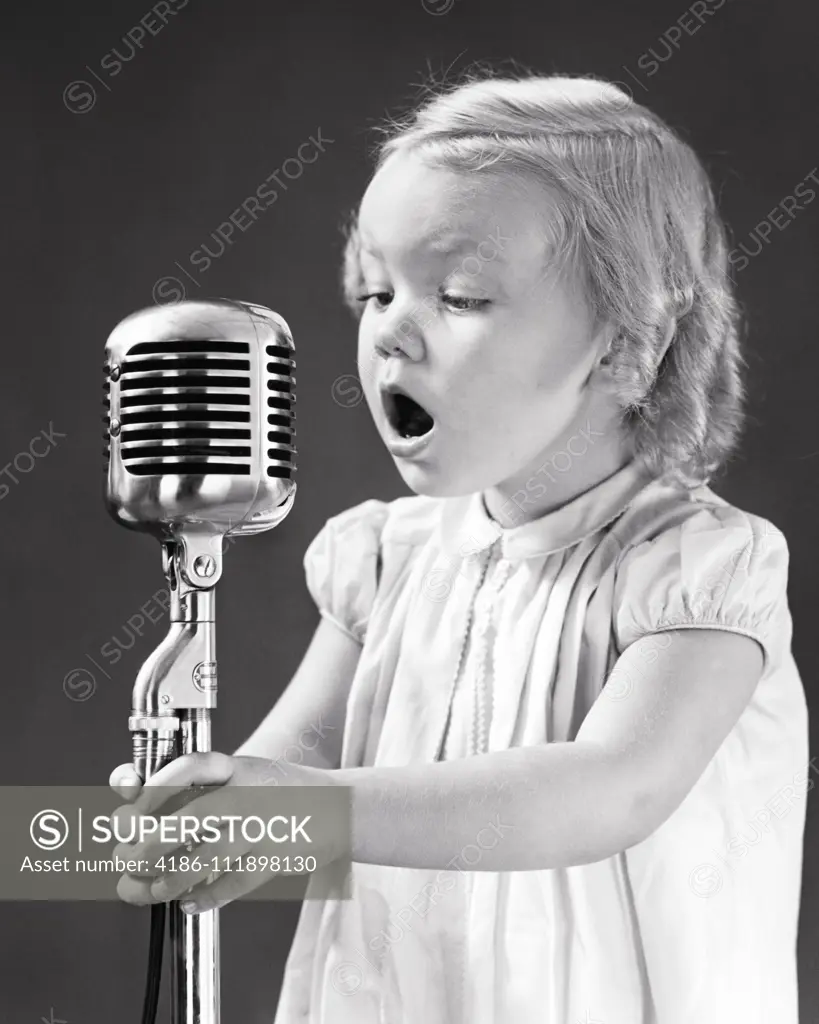 1930s 1940s EAGER YOUNG BLOND GIRL HOLDING SINGING INTO MICROPHONE