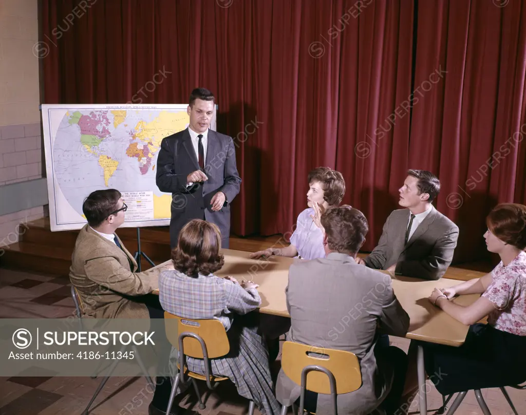 1960S Group Of Students Around Table Teacher Standing By Map