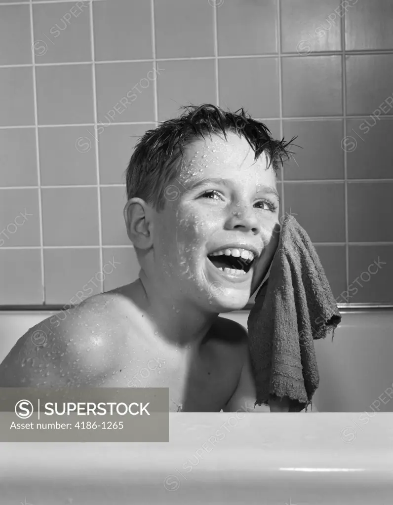 1950S 1960S Smiling Boy Washing Face Sitting In Bathtub