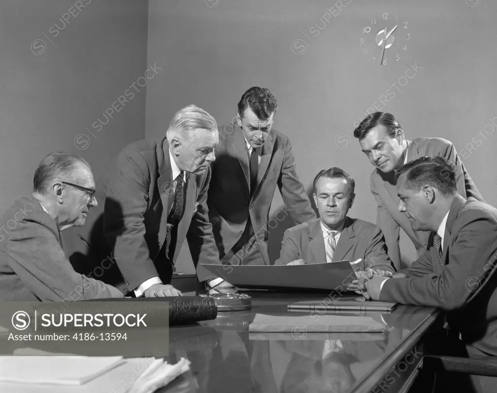 1950S Group Of Six Men Around A Chart