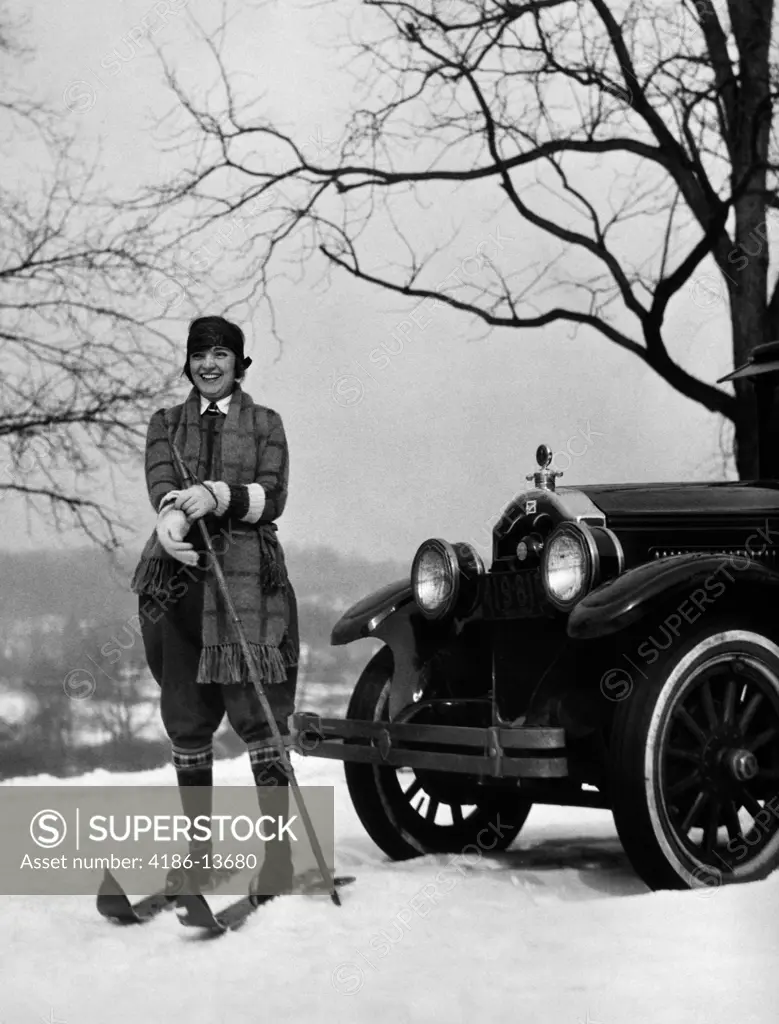 1920S Woman On Skis Standing In Front Of Car Pulling On Glove