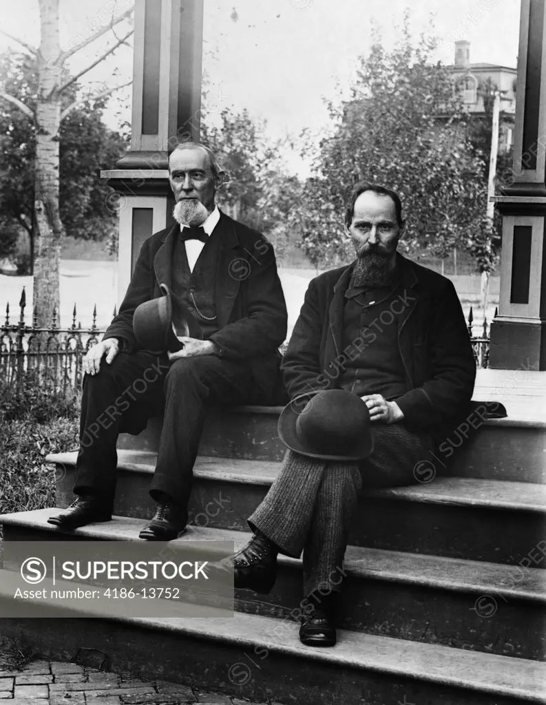 1890S Turn Of The Century Two Bearded Men Father And Son In Suits Holding Bowler Hats Sitting On Stairs In Front Of House