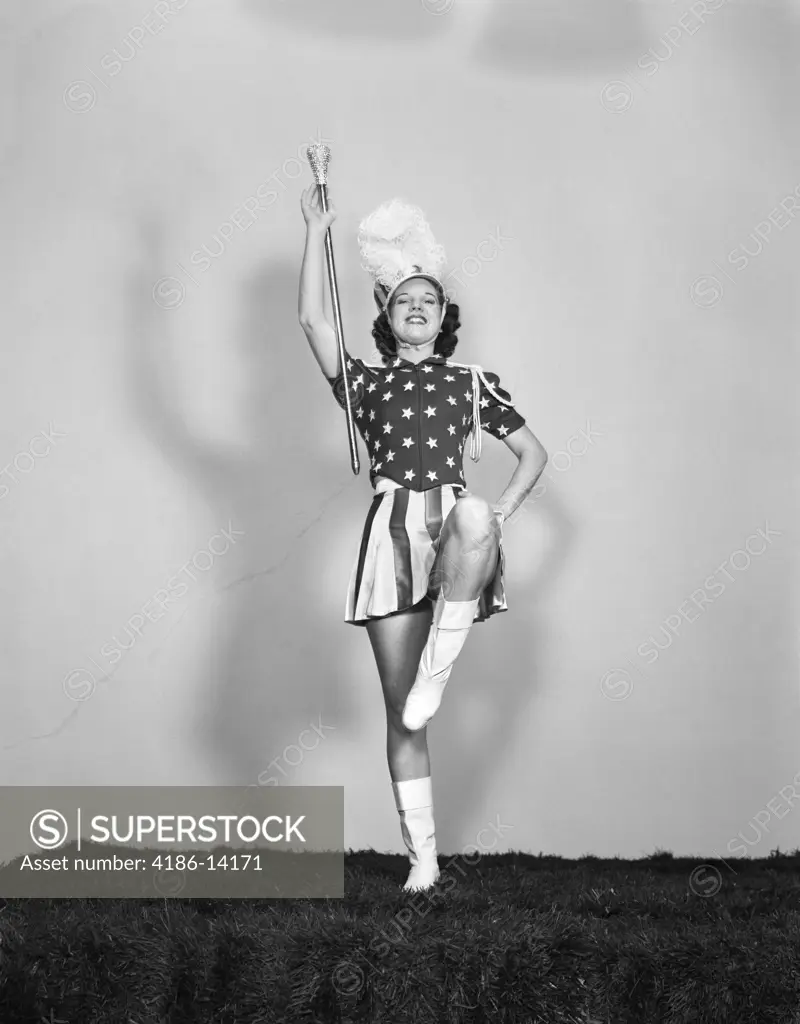 1940S Majorette Posing With Baton Facing Forward Wearing Patriotic Stars And Stripes Uniform With White Boots And Plumed Hat