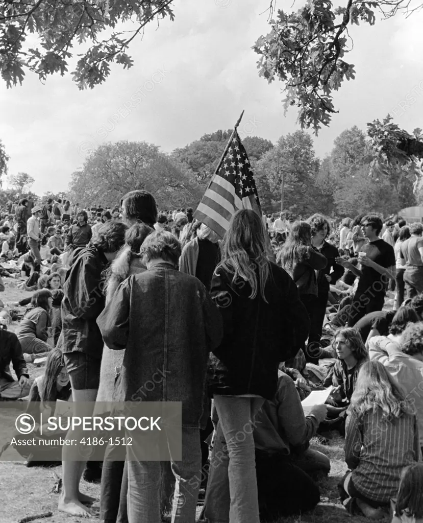 1970S Back View Of Crowd Of Young Men & Women Teenage Students Participating In Protest Demonstration Holding American Flag