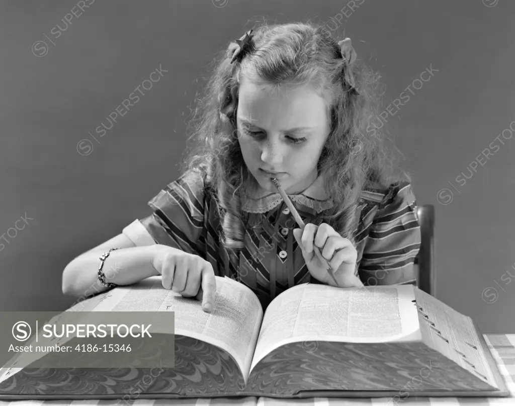 1940S Young Girl Looking In Dictionary Holding Pencil To Chin