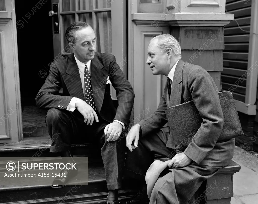 1930S 1940S Salesman And Home Owner Man Sitting Together On Front Stoop Talking Sales Presentation